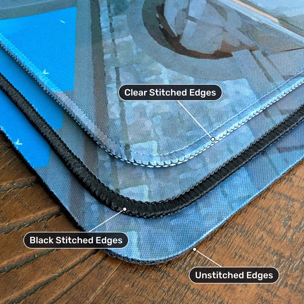 Playmat edge options compared on a wooden table: clear stitched, black stitched and unstitched edges